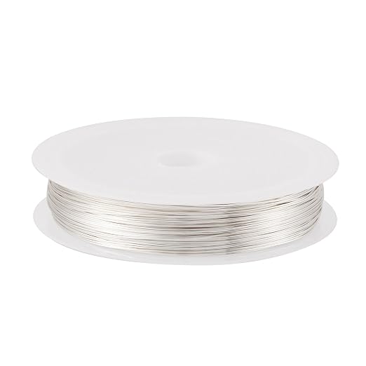 Spool of silver wire on a white background