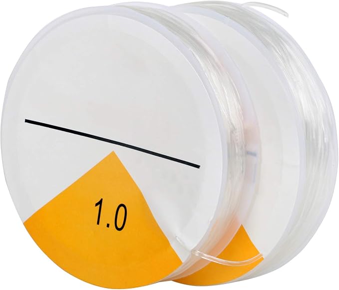 A spool of clear thread or filament with a white and orange label showing the text '1.0' and a black line diagram, isolated on a white background.