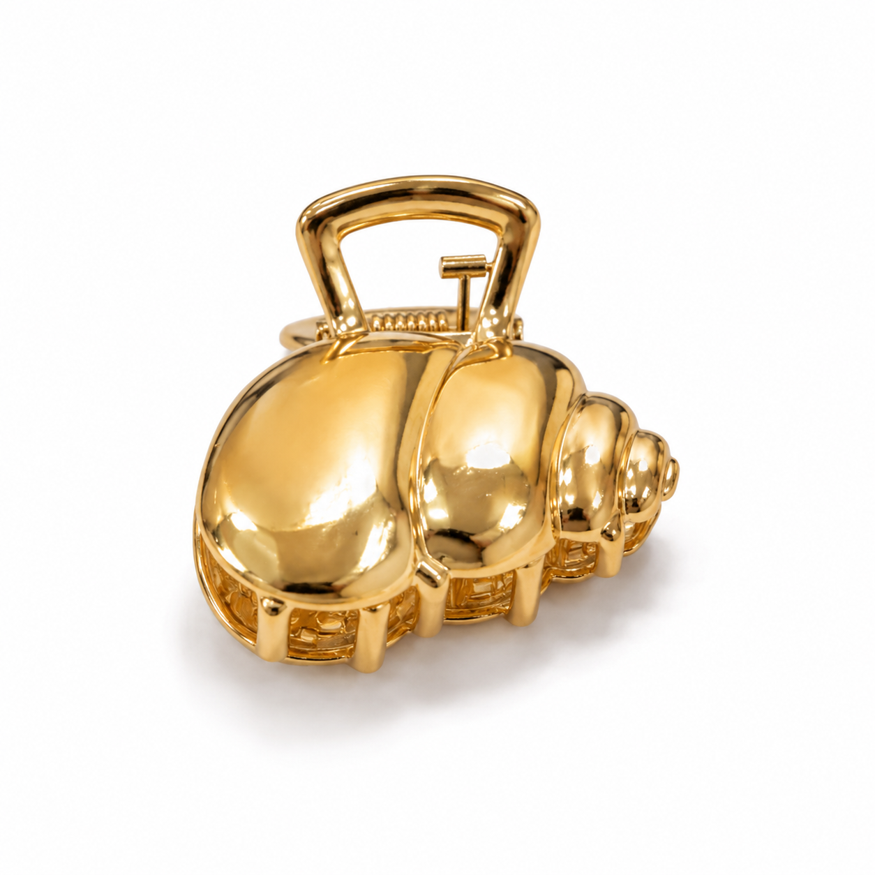 A shiny gold-toned shell-shaped accessory with a loop handle, photographed on a clean white background.