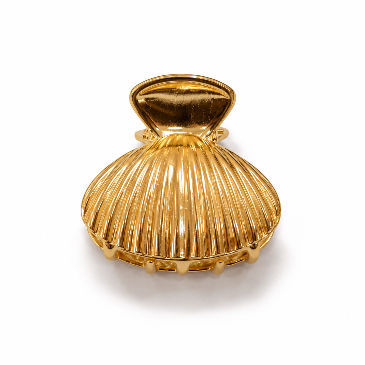A gold shell-shaped hair claw clip with a ribbed texture and a hinged top clasp, shown on a plain white background.