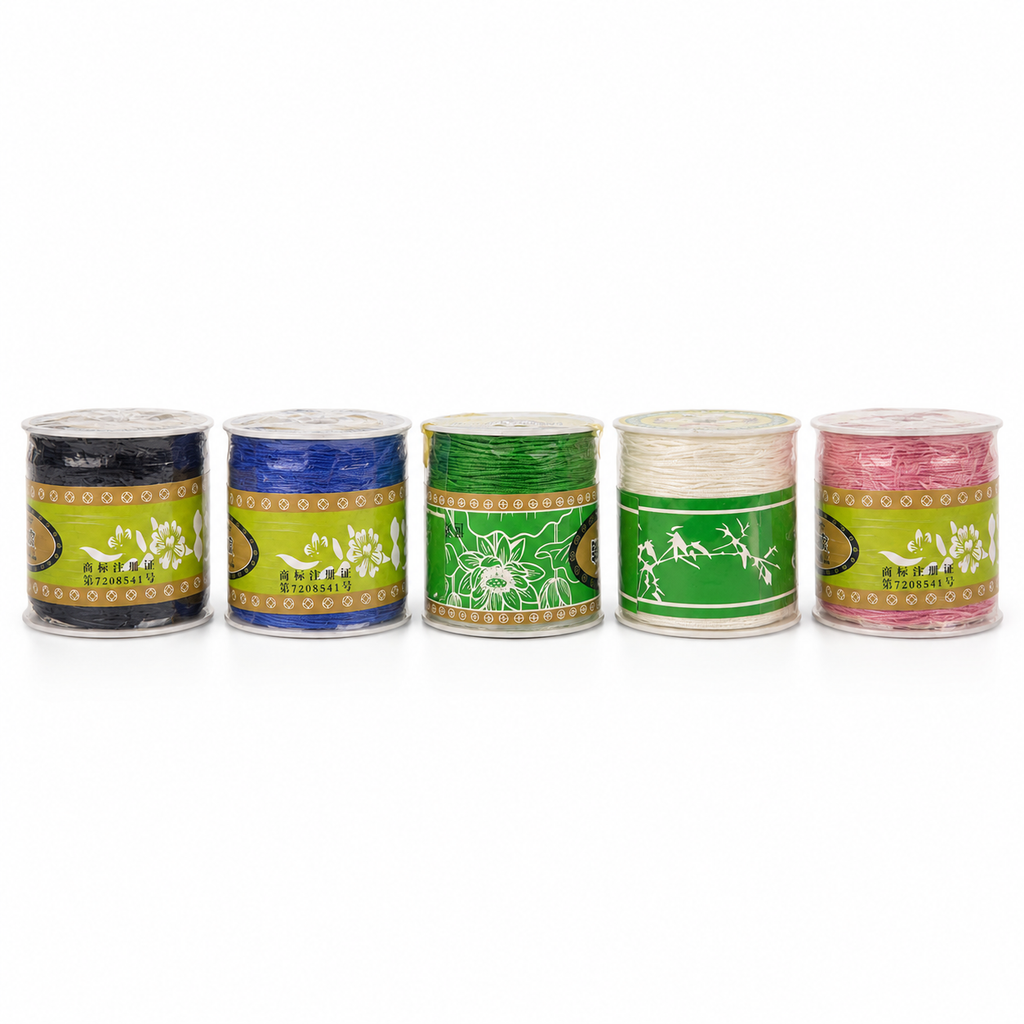 Five spools of embroidery thread in different colors (black, blue, green, white, and pink) lined up on a white background. Each spool has a green and gold label with the brand name 'SHIYAN'.