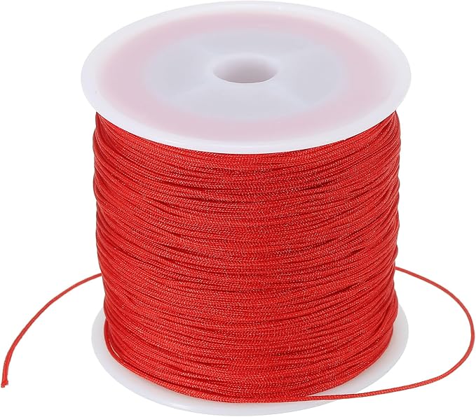 A spool of bright red cord or thread wound tightly around a white plastic core, shown on a plain white background.