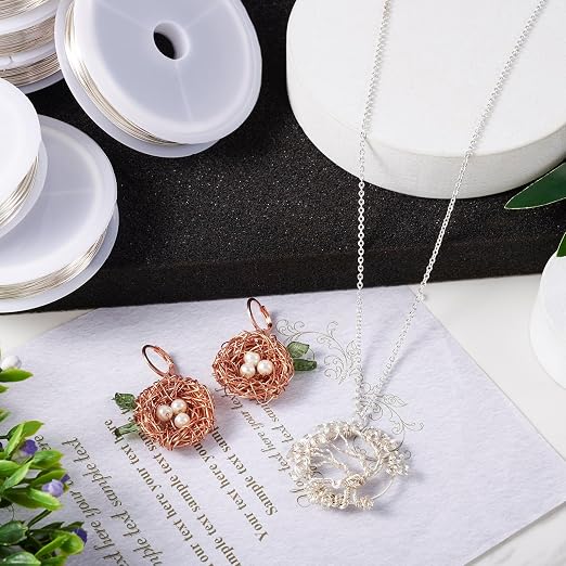 Jewelry set with a necklace and earrings on a white surface with greenery.