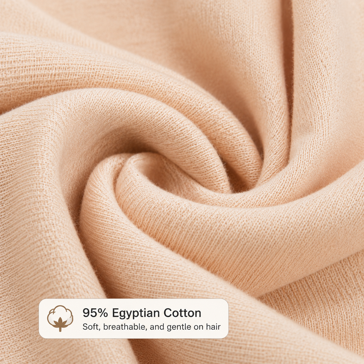 Close-up لقماش بيج ناعم من 7agatshopping مع texture واضح وتفاصيل خامة فاخرة، يظهر عليه label مكتوب 95% Egyptian Cotton مع وصف soft, breathable, and gentle on hair، بتصميم clean و elegant مناسب لعرض جودة منتجات fashion & hair accessories.

