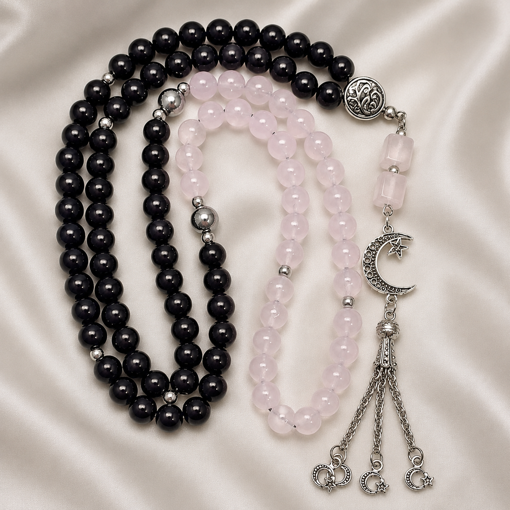 Black and pink beaded necklace with silver accents on a satin background